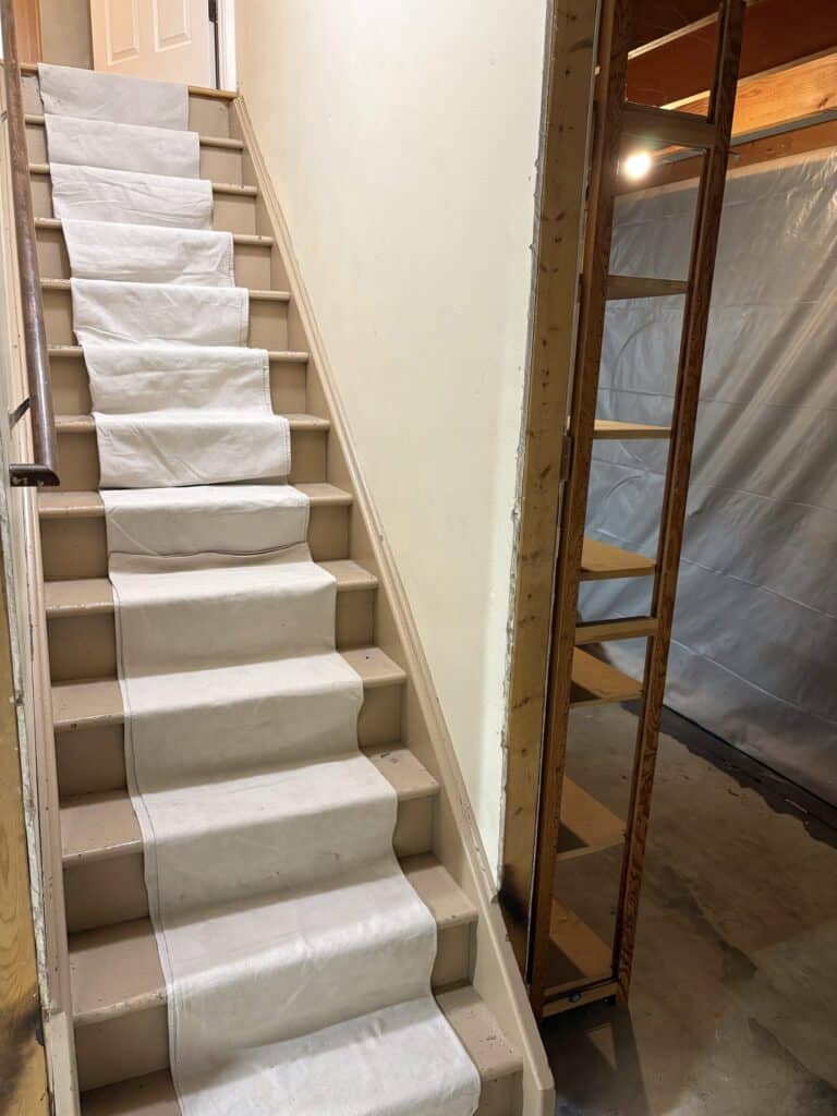 Poly-backed canvas tarp running the full length of a basement staircase